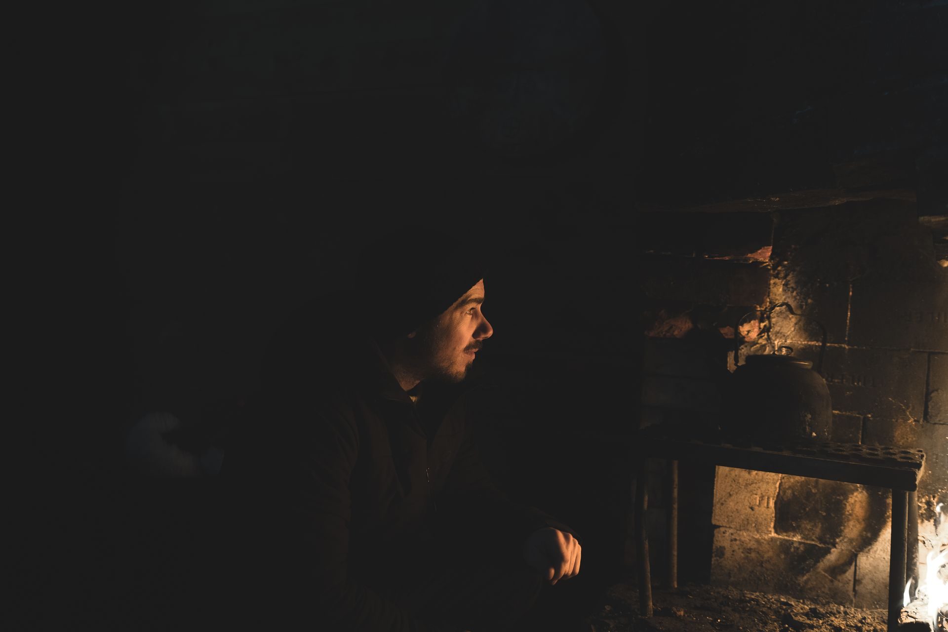 A small group gathered around a campfire under the arctic night sky.