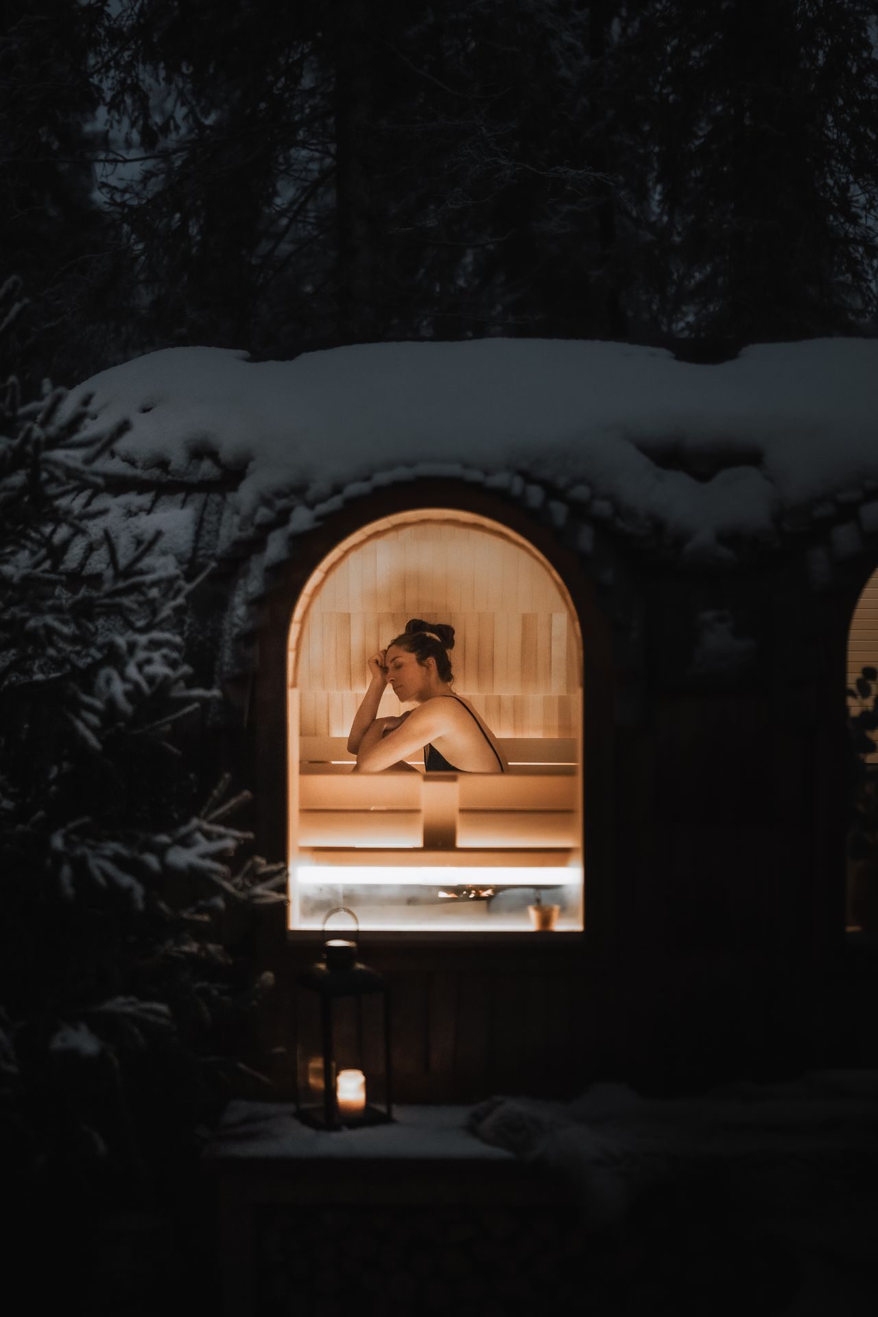 The forest sauna and cabin at Sixty Eight North in the blue light of a Lapland evening.